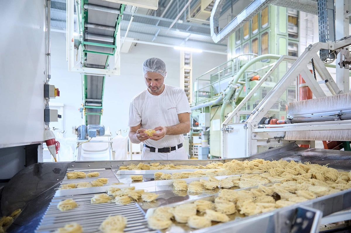Bschüssig Mitarbeiter kontrolliert Teigwaren in der Produktion